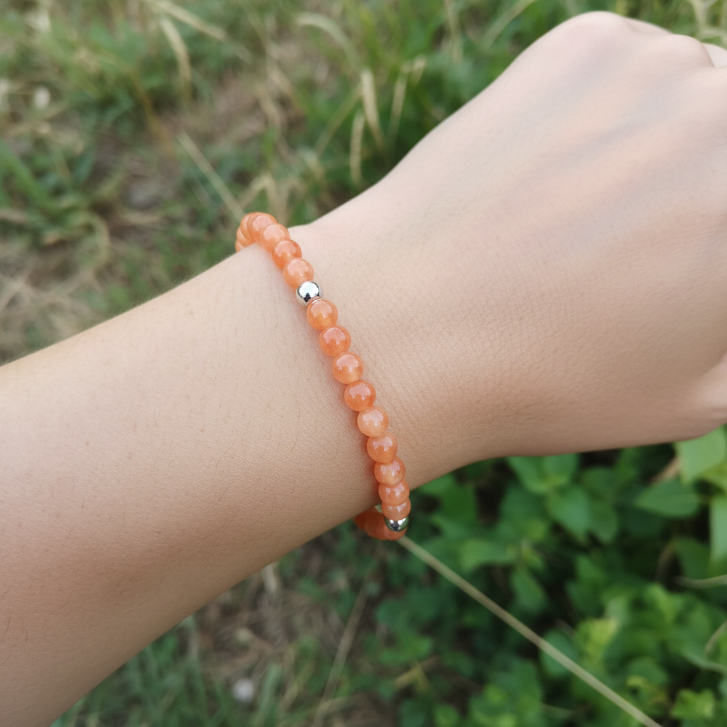 Bracelet jaspe orange fait main porté au poignet - perles naturelles aux nuances orangées lumineuses et finitions acier inoxydable - BySHELLDA