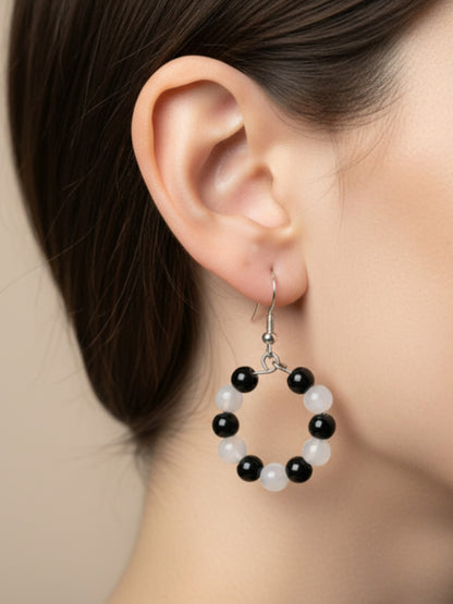 Gros plan pierres naturelles agate noire reflets pierre de lune créoles BySHELLDA