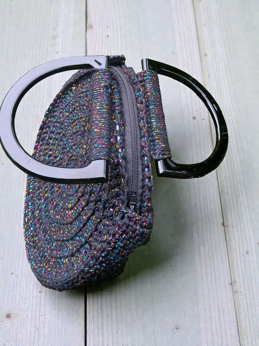 Détail du sac au crochet noir, montrant les reflets brillants et la texture artisanale.